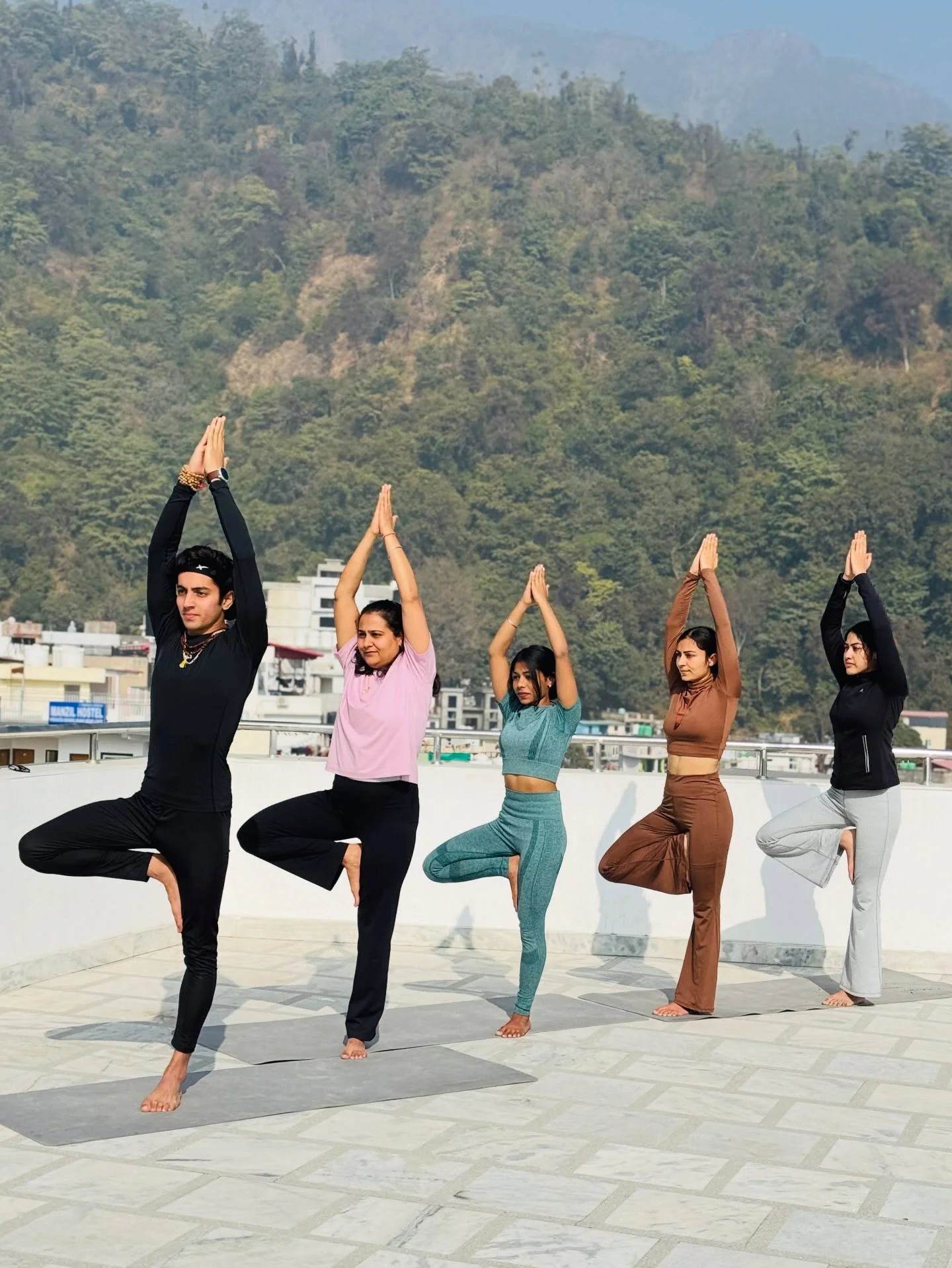 A teacher adjusting a headstand on the banks of the Ganga, Rishikesh