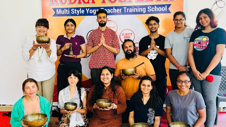 Sound healing teacher training group holding Tibetan singing bowls at Rudra Yogpeeth, Rishikesh