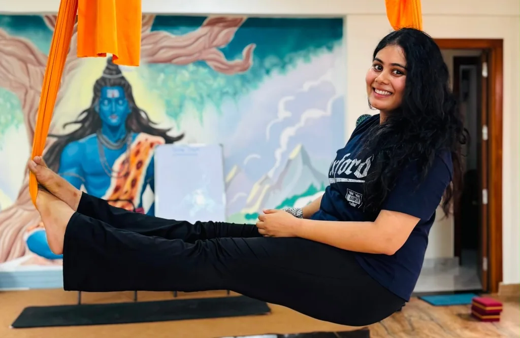 Aerial yoga student seated in the silks at Rudra Yogpeeth
